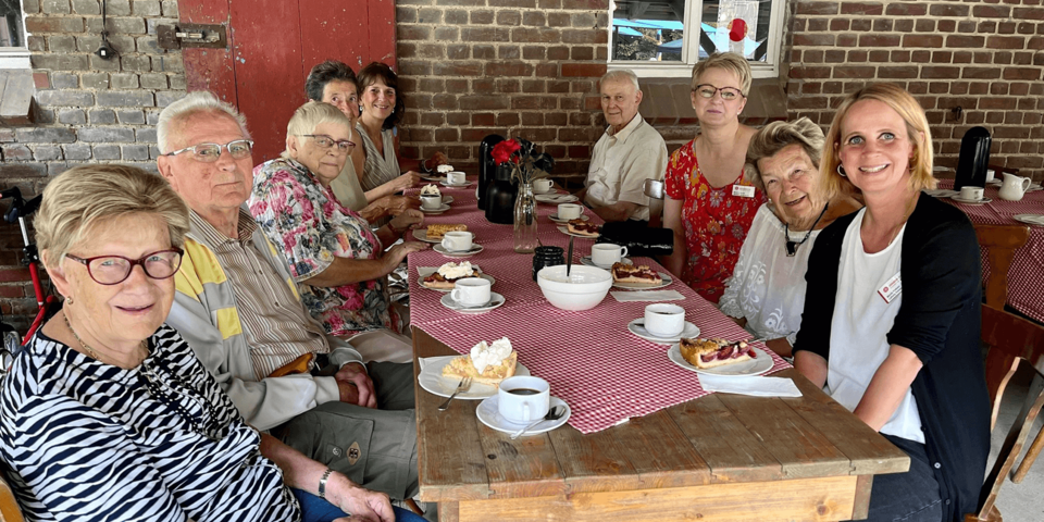Menschen am gedeckten Kaffeetisch