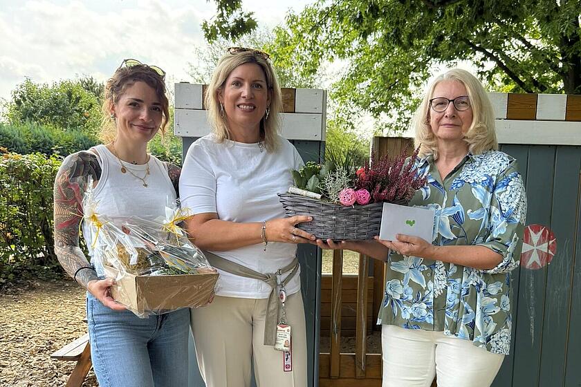 drei Frauen mit Präsent in den Händen 