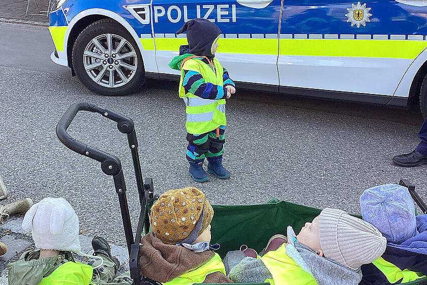 Ein Polizeiwagen besucht die Krippenkinder der Biberbande